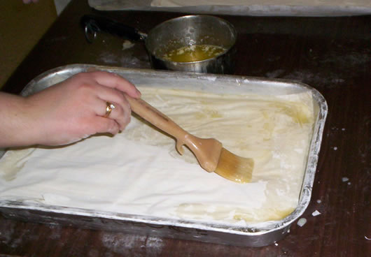 Brushing butter on a layer of filo while making baklava