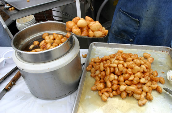 Removing loukoumades from the fryer